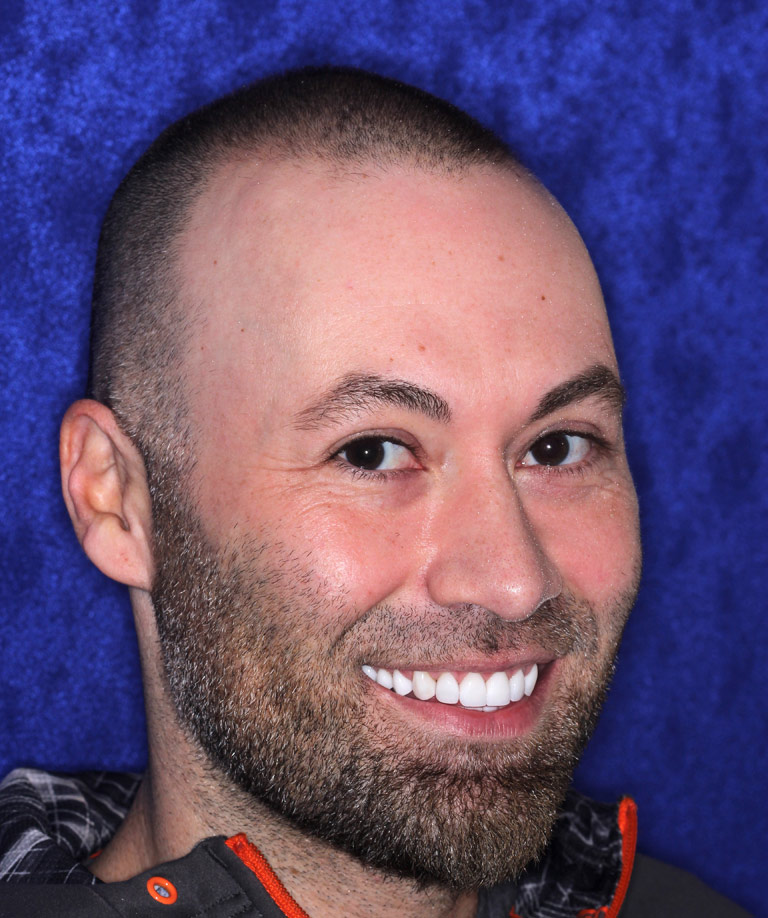 Headshot photo of Christopher smiling showing smile makeover results from Dr. Brooksher